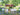 White Dash benches and Dot ottomans on a stone terrace beside a pond and covered bridge