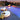 White oval ottoman and floor pad beside a pool with a fire bowl at dusk