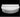 Studio view of a white Roll bolster resting along the back of a Moon Pad on a black background
