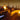 White Puck round ottoman beside a bench and fire table on a night-time terrace overlooking city lights