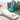 White Surf sun lounge on sand in front of weathered posts with a teal ball and a folded towel