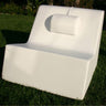 Vibe massage pillow resting at the head of a white La Fête lounge on a lawn