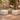 Two Zest corner ottomans in white vinyl beside a stone pedestal table in a candlelit spa courtyard
