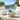Two Zig armless chairs in pale vinyl facing each other across a travertine drum table beside a pool