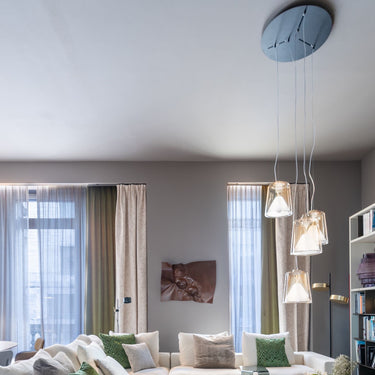 Lanterna 477 amber pendant lights by Oluce hanging in a living room