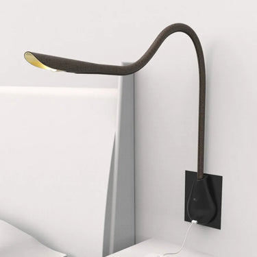 Directional brown leather Cobra wall light by Innermost, featuring a movable arm and gold interior for focused illumination.