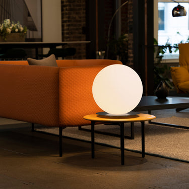 16-inch Bola Sphere Table Lamp by Pablo Designs, orange sofa environmental photo