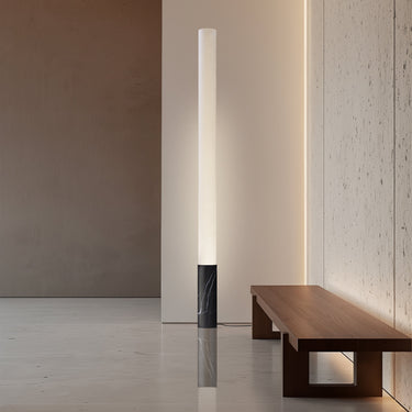 Black Elise floor lamp by Pablo beside a walnut bench