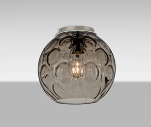 Bombay Smoke globe glowing, showing the circular optic pattern | Besa Lighting