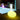 Smart & Green Flatball XL lamp glowing yellow on a wooden deck beside a lit pool