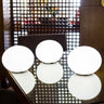 Four Smart & Green Flatball XXS lamps glowing white on a mesh-top table