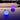 Two Smart & Green Rock lamps floating on the water at dusk, glowing violet and blue