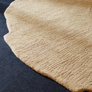 Eye Flower wool rug in Beige, styled in a room