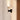 Close-up of a lit Torres wall light with an alabaster shade on a plaster wall beside a wood door