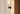Close-up of a lit Torres wall light with an alabaster shade on a plaster wall beside a wood door