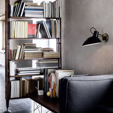 Astep VV Cinquanta Wall wall light, black reflector beside a bookcase