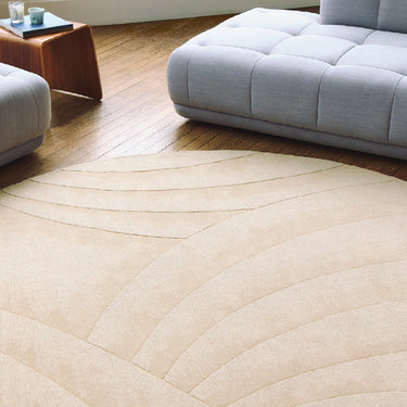 Volute Round wool rug in Beige, styled in a room