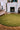 Volute Round wool rug in Green, styled in a room