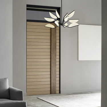 Entryway lit by a black Belterra 38 chandelier next to a warm wood door
