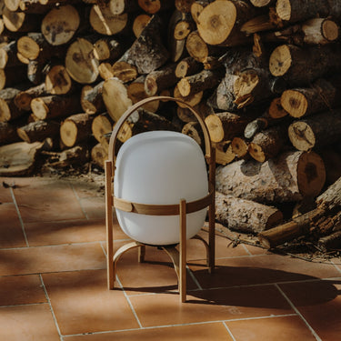 Portable Santa & Cole table lamp with opal shade and wood handle