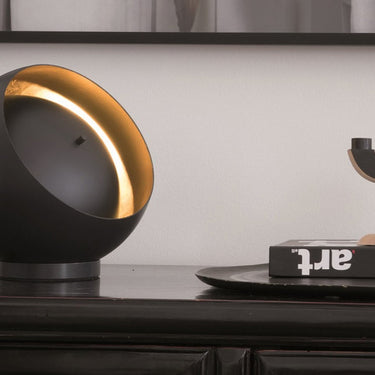 Designer metal table lamp with spherical shade and gold leaf interior, ideal for hotel bedside lighting