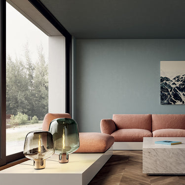 Designer Flar Medium Table Lamp by Patrick Norguet casting an ambient glow in a hotel lobby setting.