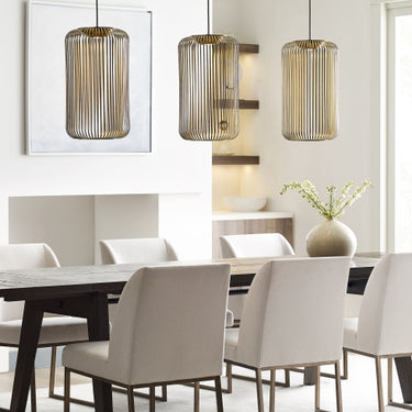 Three Kai 1 modern pendant lights in a row, creating a dramatic statement in a dining room.