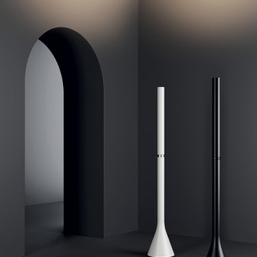 Modern LED uplight floor lamp, Croma by Lodes, illuminating a living room with warm dim ambient light.