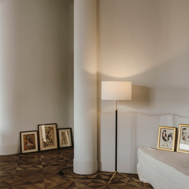 Adjustable Santa & Cole Pie de Salon G1 floor lamp beside a contemporary lounge chair