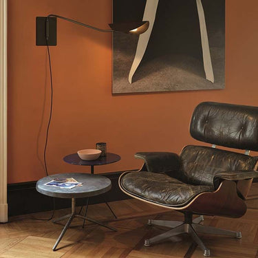 Contemporary bronze wall sconce by Oluce with folded feather-inspired metal shade
