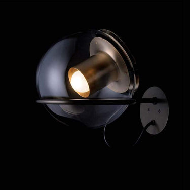 Oluce Globe Wall Lamp featuring transparent blown glass shade and metal base for boutique hotels